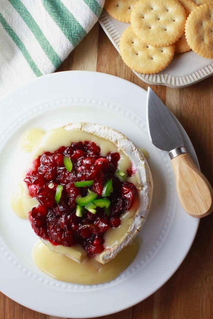 This delicious sweet and spicy brie recipe comes together without a whole lot of work involved. Just warm the brie and top with a simple 10 minute cranberry jalapeño sauce. It's so creamy and such an unusual combination, it will be gone in no time!