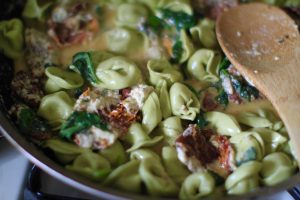 Sun-dried tomato basil tortellini with creamy spinach and cheese sauce.